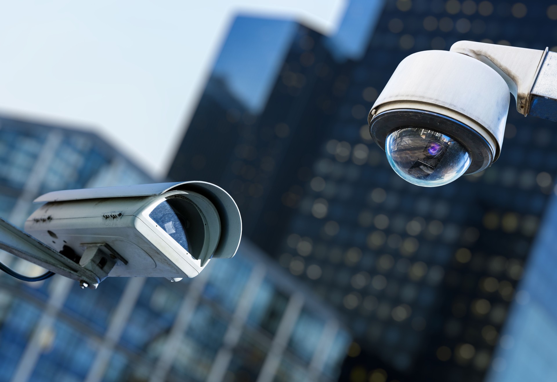 deux caméra de sécurité dans une ville avec blury entreprise bâtiment sur fond